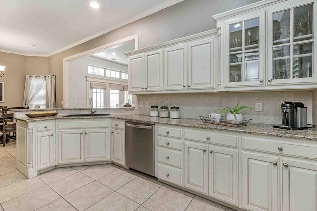 kitchen with stainless steel dishwasher, a sink, crown molding, light tile patterned flooring, and glass insert cabinets