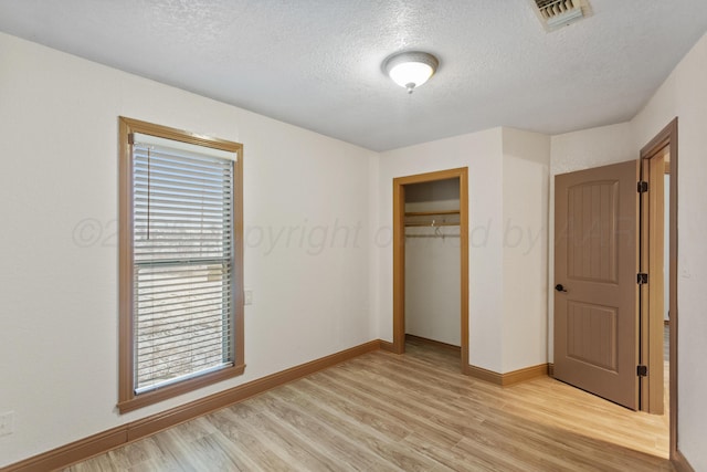 431 Crest, Pampa, TX 79065 - unfurnished bedroom with light wood-style floors, a textured ceiling, baseboards, and a closet