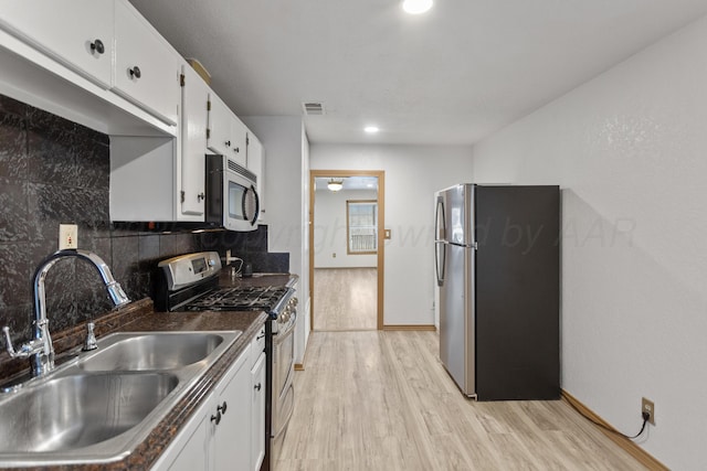 431 Crest, Pampa, TX 79065 - kitchen with appliances with stainless steel finishes, a sink, light wood finished floors, backsplash, and dark countertops
