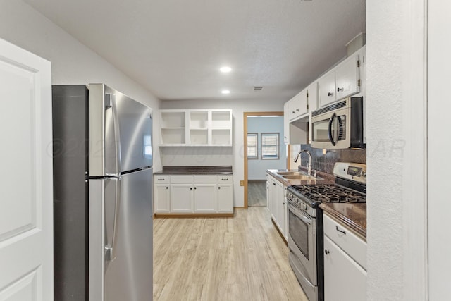 431 Crest, Pampa, TX 79065 - kitchen featuring appliances with stainless steel finishes, a sink, open shelves, dark countertops, and white cabinetry