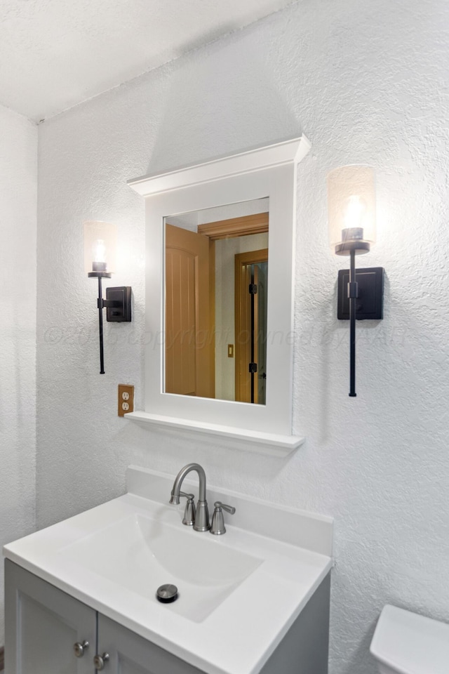 431 Crest, Pampa, TX 79065 - bathroom with vanity, a textured wall, and toilet