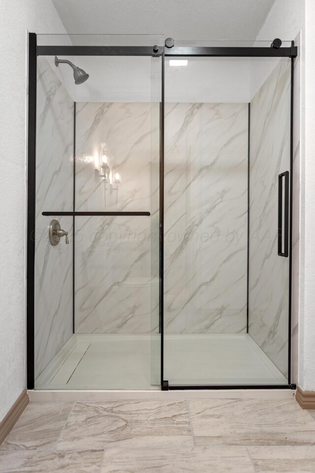 431 Crest, Pampa, TX 79065 - bathroom featuring a marble finish shower, baseboards, and marble finish floors