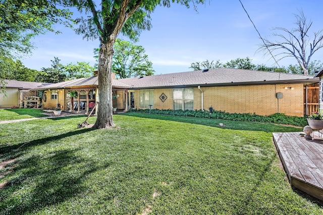 227 Ranger St, Hereford, TX 79045 - view of front of house featuring brick siding, a front lawn, a deck, a chimney, and roof with shingles