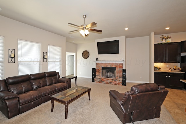 carpeted living room with a fireplace and ceiling fan