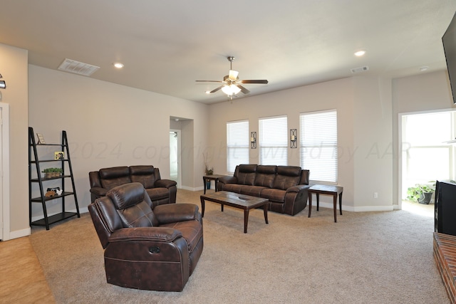 living room featuring light carpet and ceiling fan