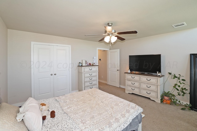 carpeted bedroom featuring a closet and ceiling fan