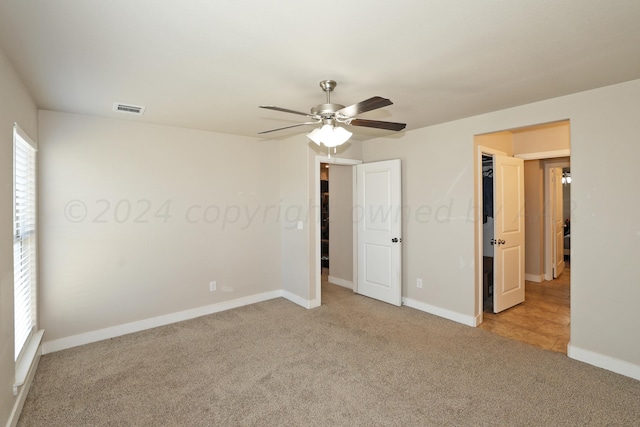 unfurnished bedroom with light carpet and ceiling fan