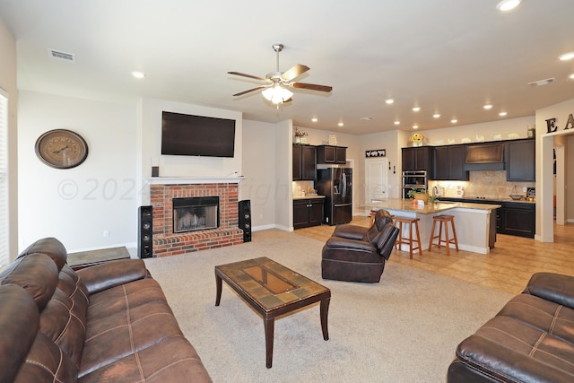 living room featuring a fireplace and ceiling fan