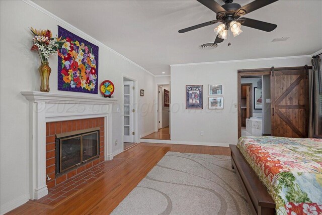 100 S Avondale St, Amarillo, TX 79106 - bedroom with wood finished floors, a barn door, ornamental molding, a fireplace, and a ceiling fan