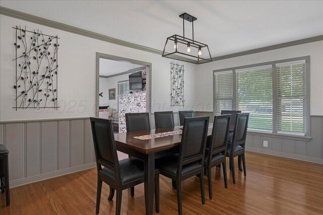 100 S Avondale St, Amarillo, TX 79106 - dining area featuring wood finished floors, crown molding, a decorative wall, and a wainscoted wall