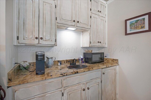 100 S Avondale St, Amarillo, TX 79106 - kitchen featuring black microwave, light stone countertops, and white cabinets