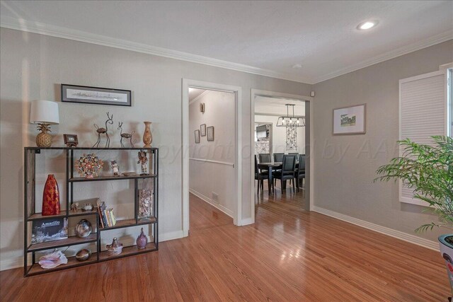 100 S Avondale St, Amarillo, TX 79106 - hall featuring a chandelier, wood finished floors, crown molding, and recessed lighting