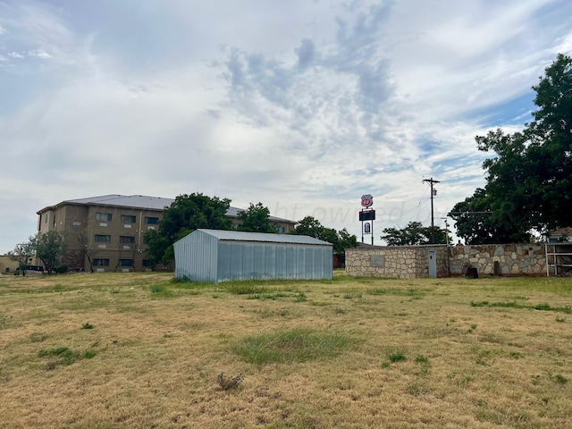 1814 N Main St, Shamrock, TX 79079 - view of green lawn featuring a pole building and an outbuilding