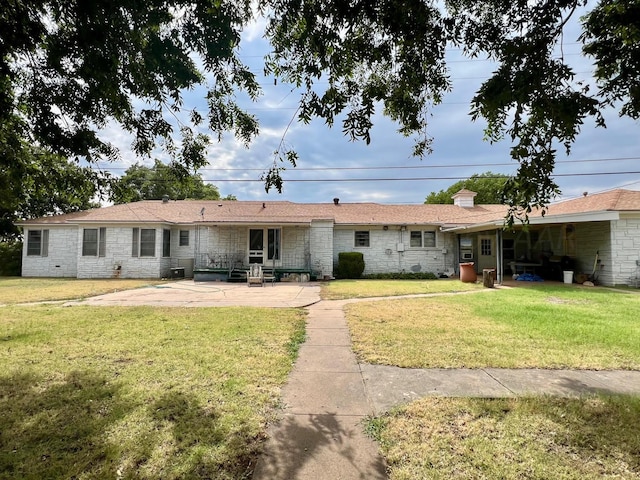 back of property featuring a patio area and a lawn