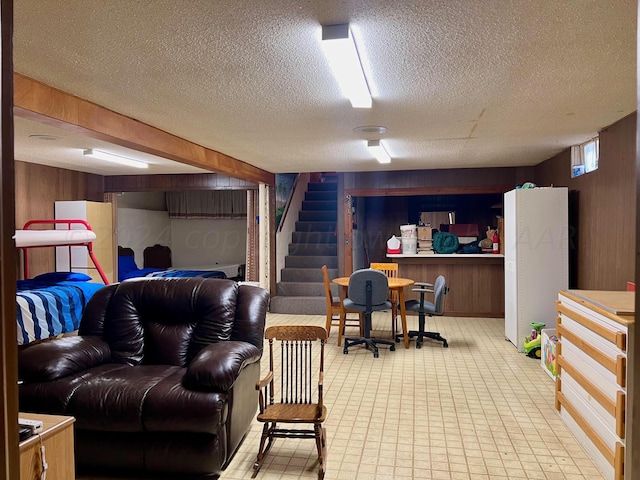 1814 N Main St, Shamrock, TX 79079 - below grade area with wooden walls, freestanding refrigerator, a textured ceiling, and stairs