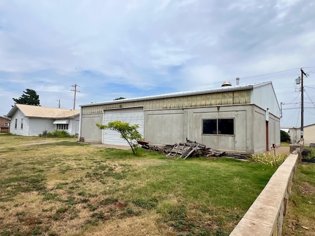 back of property featuring a garage and a yard