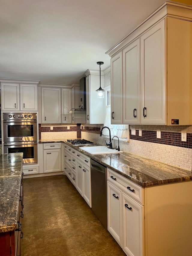 kitchen with dark stone counters, appliances with stainless steel finishes, sink, and hanging light fixtures