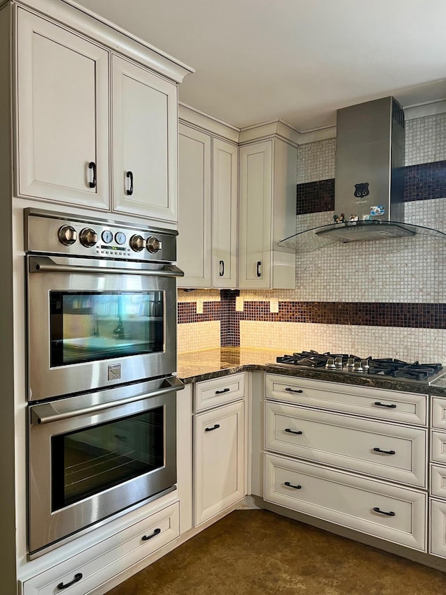 kitchen with dark stone countertops, tasteful backsplash, appliances with stainless steel finishes, and wall chimney exhaust hood