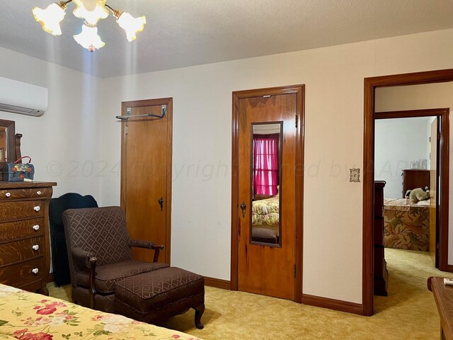 carpeted bedroom featuring a wall unit AC and a textured ceiling