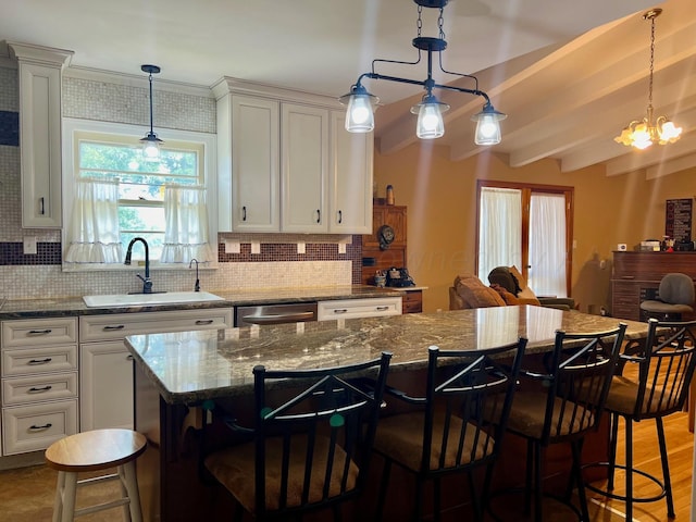 kitchen featuring light wood-type flooring, tasteful backsplash, a center island, and beam ceiling