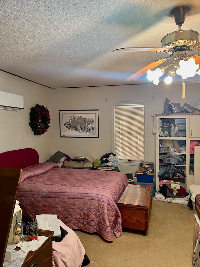 carpeted bedroom with a wall mounted AC, a textured ceiling, and ceiling fan