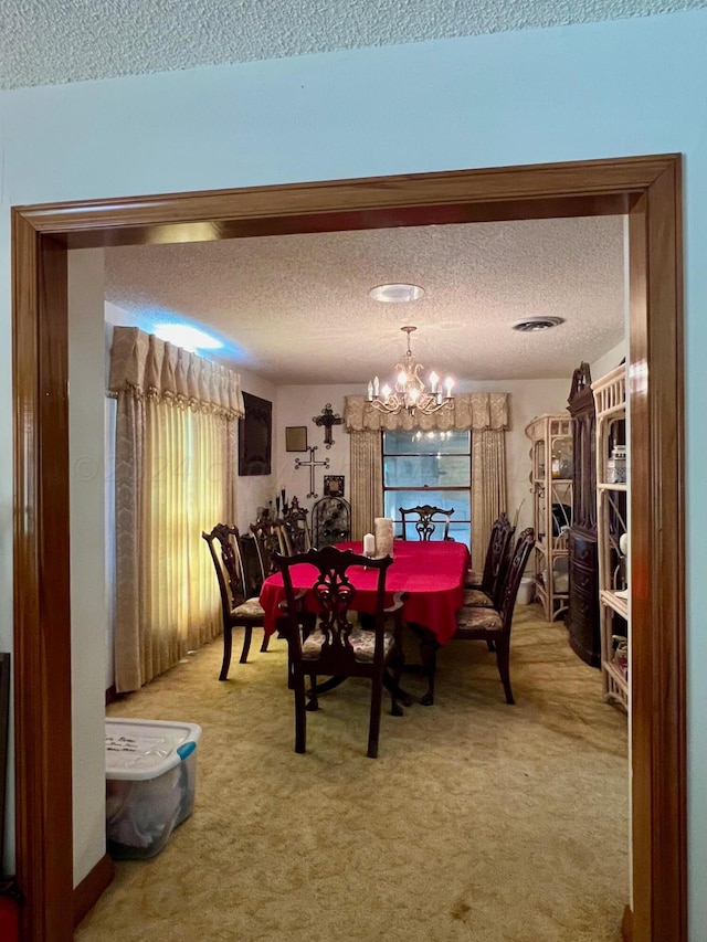 carpeted dining room with an inviting chandelier and a textured ceiling