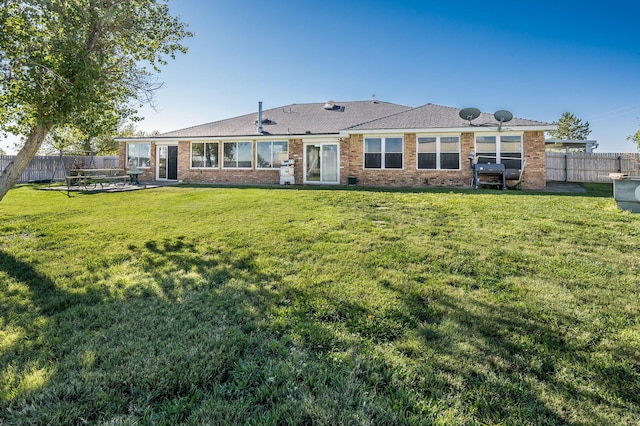 back of property featuring a lawn and a patio area