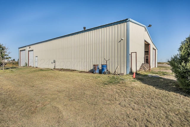 view of outdoor structure featuring a garage and a lawn