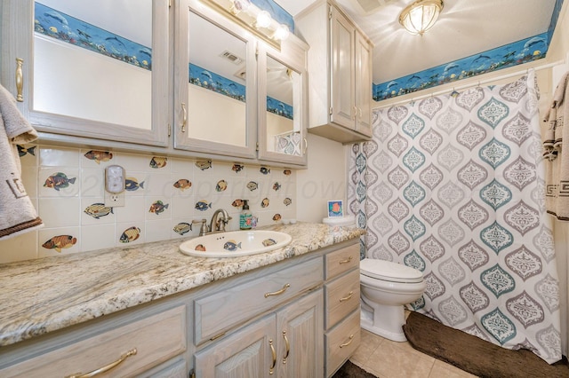 bathroom featuring tile patterned floors, vanity, toilet, and backsplash