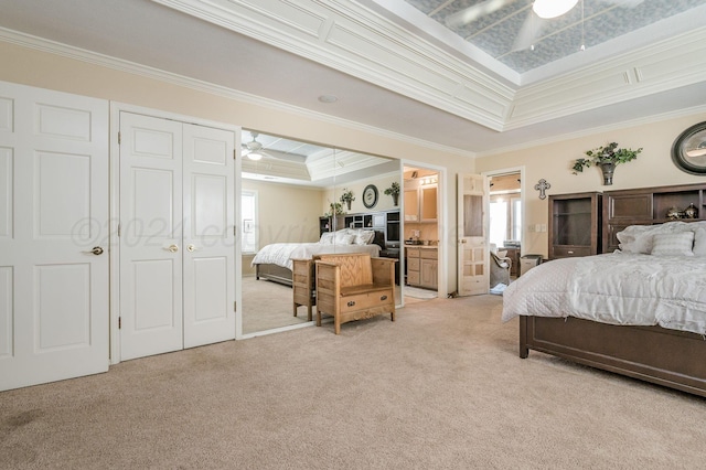 bedroom with light colored carpet, ornamental molding, and a tray ceiling