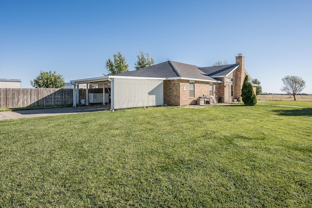exterior space with a carport and a yard