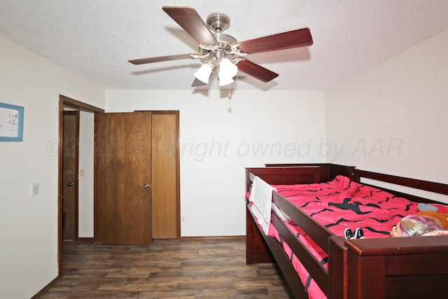 1005 Bennett Dr, Dumas, TX 79029 - bedroom with wood finished floors, baseboards, a ceiling fan, and a textured ceiling