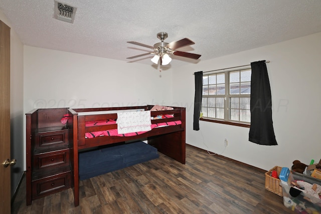 bedroom featuring a textured ceiling, ceiling fan, wood finished floors, and visible vents