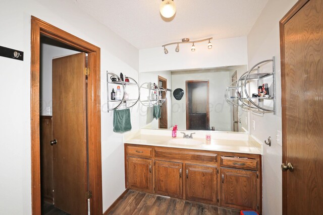 1005 Bennett Dr, Dumas, TX 79029 - bathroom featuring vanity, wood finished floors, and a textured ceiling