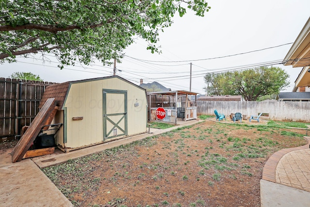view of yard with a fenced backyard, an outdoor structure, and a shed
