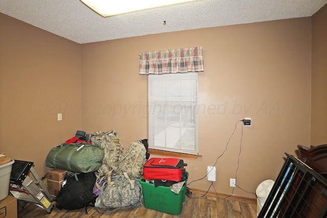 bedroom featuring baseboards, multiple windows, and wood finished floors