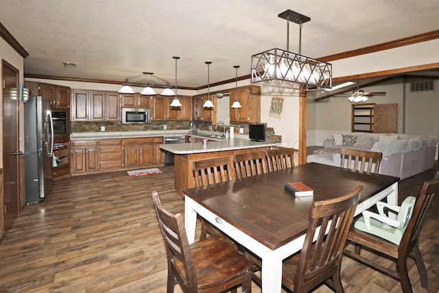 dining space with crown molding, dark wood finished floors, and visible vents