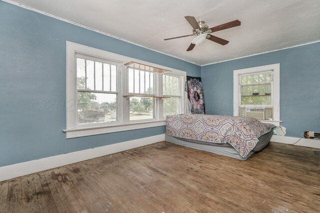 300 E 4th St, Clarendon, TX 79226 - bedroom with wood finished floors, baseboards, a ceiling fan, and cooling unit