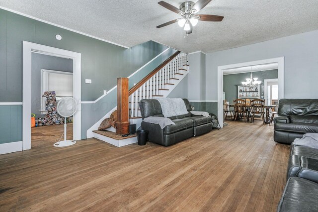 300 E 4th St, Clarendon, TX 79226 - living area featuring stairs, wood finished floors, a ceiling fan, a textured ceiling, and a chandelier