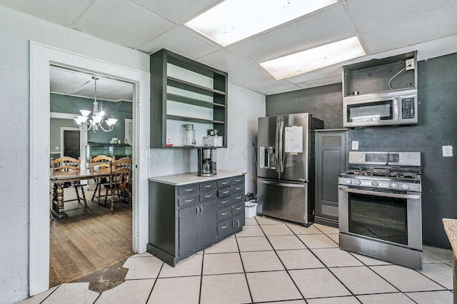 300 E 4th St, Clarendon, TX 79226 - kitchen with appliances with stainless steel finishes, open shelves, a chandelier, a paneled ceiling, and light countertops