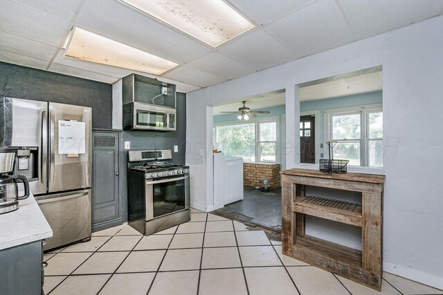 300 E 4th St, Clarendon, TX 79226 - kitchen featuring stainless steel appliances, a drop ceiling, light countertops, baseboards, and light tile patterned floors