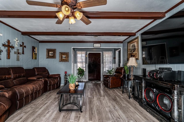 living room featuring a ceiling fan, beam ceiling, and wood finished floors