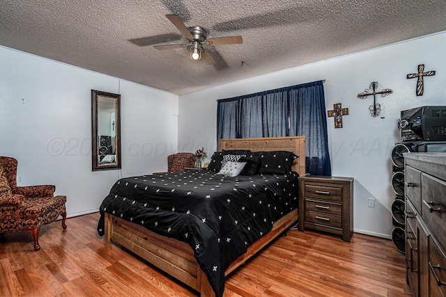 bedroom featuring ceiling fan, a textured ceiling, and wood finished floors