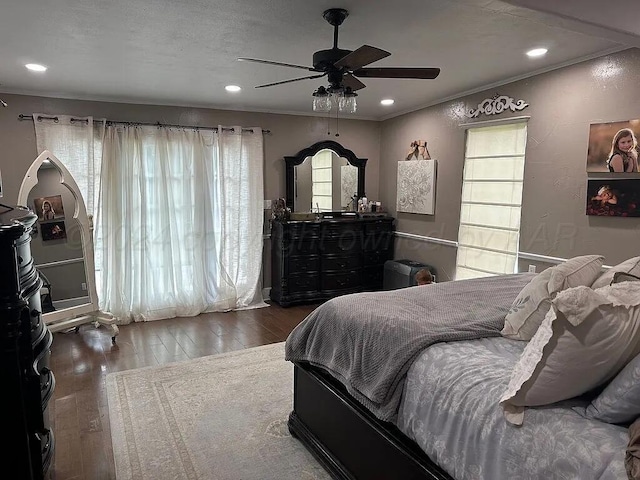 bedroom featuring ceiling fan, dark hardwood / wood-style flooring, and multiple windows