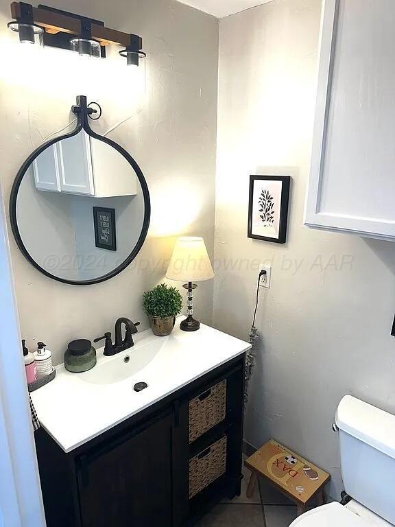 bathroom with tile patterned flooring, vanity, and toilet