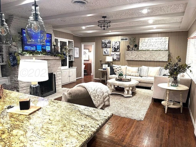 living room featuring beamed ceiling, a textured ceiling, and dark hardwood / wood-style flooring