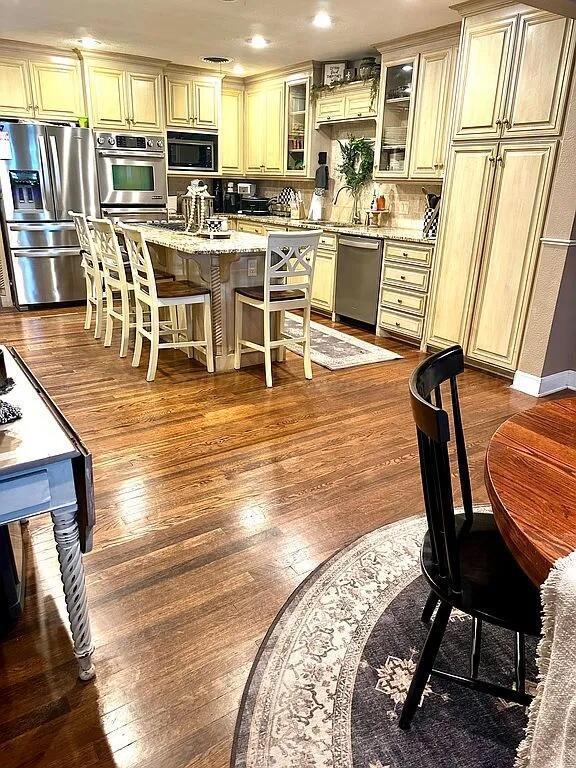 kitchen featuring cream cabinetry, hardwood / wood-style floors, and stainless steel appliances