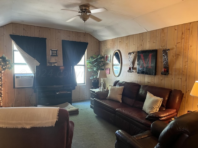 carpeted living room with wood walls, ceiling fan, plenty of natural light, and vaulted ceiling