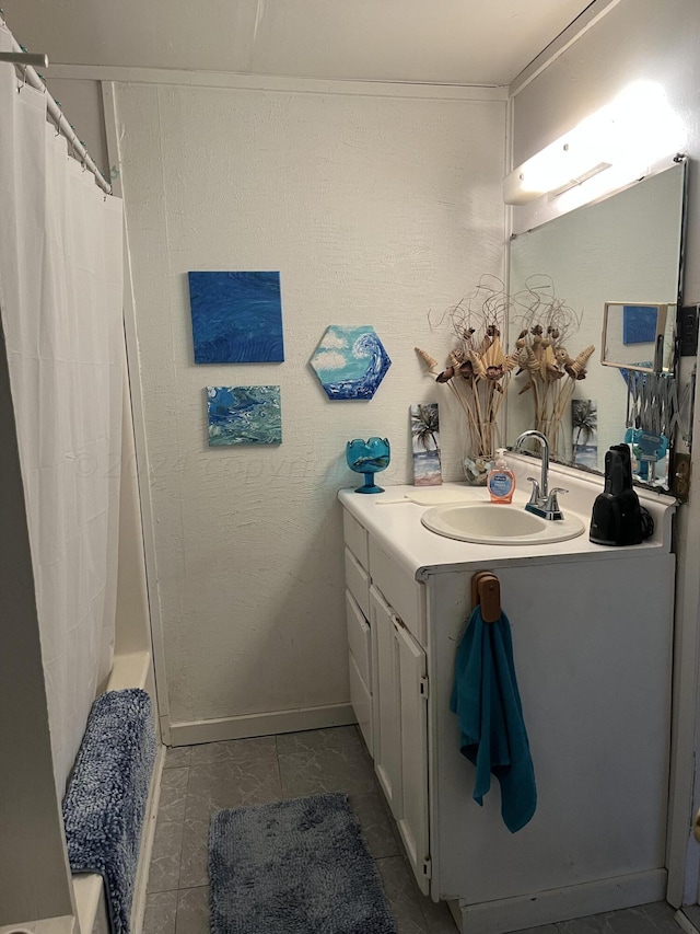 bathroom featuring walk in shower, vanity, and tile patterned floors