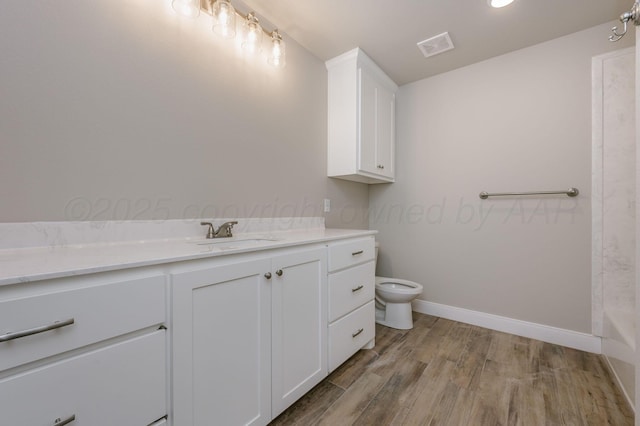 bathroom with a tub to relax in, toilet, vanity, and hardwood / wood-style flooring